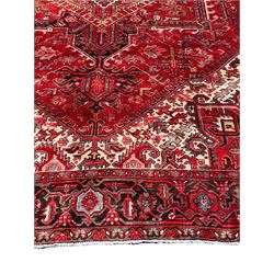 Persian Hamadan red ground rug, central floral lozenge medallion surrounded by stylised plant motifs and geometric patterns, repeating border with scrolling pattern and stylised flower heads