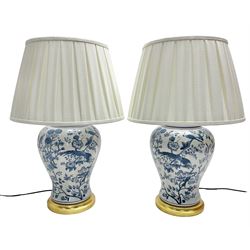 Pair of large table lamps of baluster form, decorated with exotic birds perched in flowering trees, upon gilt circular bases, H68cm