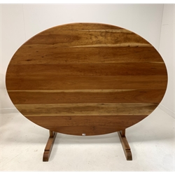 20th century French cherry wood Vineyard table, the oval top raised on joined base with 'V' shaped pivoting tilt top action, raised on shaped sledge feet