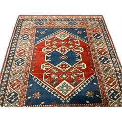 Turkish crimson ground rug, the hexagonal field with three overlapping lozenges with geometric stylised plant motifs, the multi-band border with repeating geometric designs and flower heads