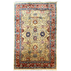 Persian Heriz pale camel ground carpet, the field with all-over palmette decoration and interlacing foliate branches, the guarded coral border with repeating stylised plant motifs and contrasting palmettes