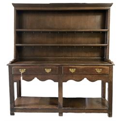 Georgian oak dresser, the projecting cornice over two-height plate rack and base, fitted with two long drawers and pot board base, raised on stile supports 