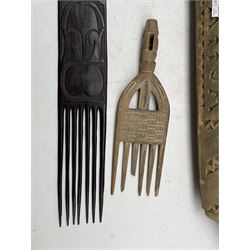 Samoan carved wooden model of a canoe L82cm, Tribal carved wooden forks and comb and a textile panel