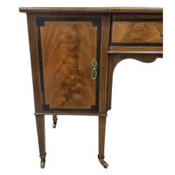 Early 19th century mahogany break-front kneehole dressing table or sideboard, figured top over central drawer and two cupboards, decorated with ebony bandings and boxwood stringing, the kneehole with shaped apron, on square tapering supports with brass cups and castors