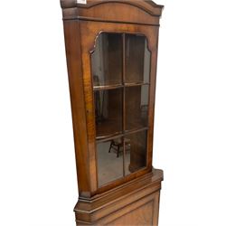 Mid 20th century walnut corner cabinet, fitted with one glazed door opening to reveal two shelves over one cupboard door with one shelf, raised on bracket supports 