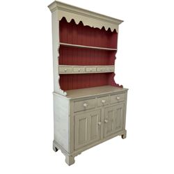 Cream painted dresser, the projecting cornice over two height plate rack with drawers, over three drawers and two cupboard doors, raised on bracket supports 