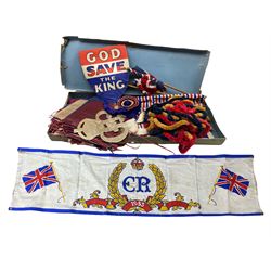 George VI Coronation banner, later stencilled for Queen Elizabeth II coronation, 'God Save The King' card shield, two flags, bunting, serviettes and other related decorations 