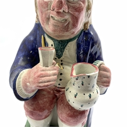 Pratt Type pottery toby jug of traditional form holding a cup and jug on a sponge base, H26cm