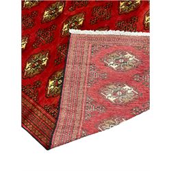 Large Afghan red ground carpet, decorated with repeating Gul motifs, in multiple band border with geometric design