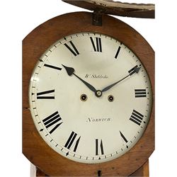 William Shildrake of Norwich – mahogany 8-day striking wall clock c1850, with a long trunk and concave topped trunk door, circular wooden bezel with rope-twist carving and stepped base, painted dial with makers name, Roman numerals and minute track with matching heart shaped steel hands, dial pined via a cast Finmore falseplate to a rack striking movement with a recoil anchor escapement. With weights and pendulum.  
William Shildrake is recorded as working from London Street, Norwich 1822-64. 
