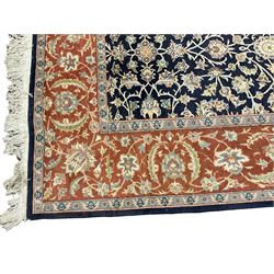 Persian indigo ground carpet, the field decorated with all-over scrolling foliate vines with interlaced palmettes and plant motifs, the guarded red border with repeating swirls of flower heads and palmette designs