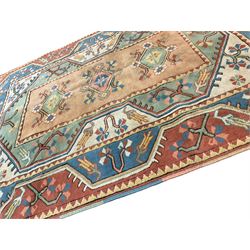 Turkish Milas rug, peach central field with three lozenges with flower heads, the extending borders with geometric foliate designs and stylised plant motifs (144cm x 199cm); and antique Turkish red ground rug, decorated with boteh motifs and stylised flower heads (166cm x 128cm)