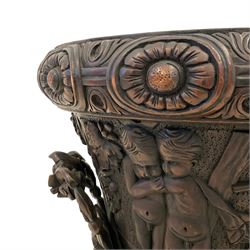 Pair of mid-to-late 20th century Baroque Revival carved wood Campana-shaped urns, the lid with pineapple finial over scrolled acanthus leaf, oval flower head carved band over the main body decorated with festival scenes, the underbelly carved with green man masks and scrolling foliate, the handles in the form of scrolled leafage, the foot carved with an interlaced band and beads over the foliate carved circular platform, octagonal base with foliate edge and scroll carvings to each panel 