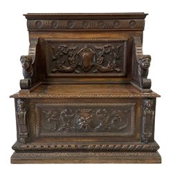 18th century style oak settle, the back panel with carvings of mermaids and folate decoration with masked arms over hinged seat and base with foliate and mask carving