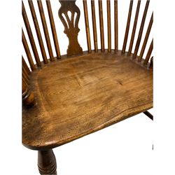 Early 19th century Windsor armchair, the splat and spindle back over wide elm seat, raised on turned supports 