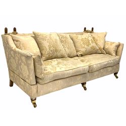 Knole drop arm three seat sofa, upholstered in ivory floral damask, raised on square tapered supports with brass cup castors W200cm