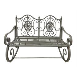 Washed grey finish wrought metal rocking garden bench seat, pierced back with scroll design over strap seat