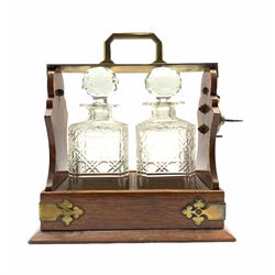 Oak two bottle tantalus with two square cut spirit decanters and traces of original silver plate H30cm