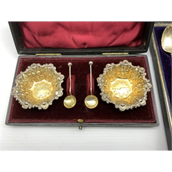 Set of six late Victorian 'Apostle' tea spoons with shell bowls, tongs and sifting spoon Birmingham 1898 Maker William Devenport, cased and a pair of silver circular salts with embossed and gilded decoration Chester 1899 Maker James Deakin & Sons, cased 