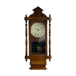 A 19th century American wall clock manufactured by the “New Haven”  clock company, in a mahogany case with an architectural pediment, decorative inlay, turned and ringed pilasters with finials and carved decoration, full length glazed door displaying a faux mercury pendulum, 8” painted dial within a wooden fretwork mask and gilt slip, with Roman numerals, minute track and steel Maltese hands, with an eight-day countwheel striking movement striking the hours on a steel bell.



