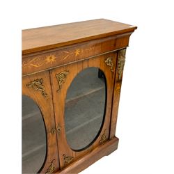 19th century walnut display cabinet, the rectangular top over a crossbanded frieze inlaid with satinwood marquetry inlay, the two doors with oval glazed panels enclosing two shelves, the figured uprights mounted with gilt metal busts of medieval figures over trailing foliate inlay, raised on shaped plinth base