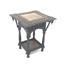  19th century Eastern oak occasional table, the top carved with trailing foliate over figures to each corner, leaf carved supports united by undertier, 51cm x 50cm, H62cm  