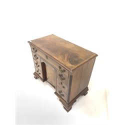 Georgian style mahogany kneehole writing desk, cross banded top over one long, six short and one concealed drawer with cupboard to centre, blind fretwork to the canted corners, raised on ogee bracket supports W97c, H83cm, D51cm