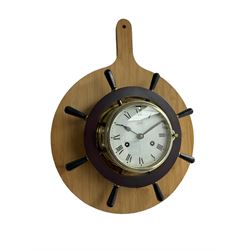 Late 20th century  German “Schatz” ships bulkhead clock in a brass case with a ships wheel surround, eight-day spring driven movement with a lever balance escapement sounding the ships hours of the watch on a bell, with a 5” white painted dial, Roman numerals, minute track and steel spade hands, fast and slow regulation, mounted on a contemporary 33cm diameter circular wooden board. With key.
