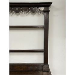 Late 18th century oak dresser and rack, the raised plate rack with projecting cornice over fretwork frieze and three heights, fitted with small spice drawers and flanked by fluted uprights, the dresser base with rectangular top over two short and two long drawers, two cupboards enclosed by fielded doors with stepped and pointed ogee arches, fluted uprights, on shaped bracket feet