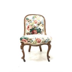 Victorian rosewood nursing chair, moulded frame and upholstered in floral linen, raised on scroll carved cabriole supports and ceramic castors W49cm
