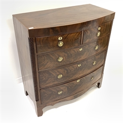 Early 19th century figured mahogany bow front Trafalgar chest of three long and two short drawers, with satinwood stringing to edge and apron, rope twist decoration to side pilasters and escutcheons, circular brass plate ring handles, shaped apron, raised on bracket supports, W101cm, H110cm, D52cm