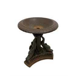 Mid-20th century classical revival cast iron birdbath, the moulded top with scalloped bowl, the central fluted column surrounded by three dolphins on a concave triangular base with pierced detail