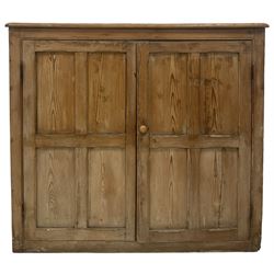Victorian pine bookcase, the rectangular top with moulded edge over two panelled doors, opening to reveal three fixed shelves, raised on a plinth base 