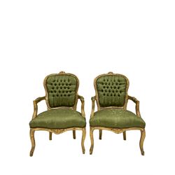 Pair French style gilt wood bedroom chairs, the cresting rail carved with flower heads, upholstered in buttoned green fabric, on cabriole supports