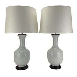 Pair of Chinese ivory crackle glazed table lamps, each of bottle form, raised upon circular hardwood bases, H43cm excluding fitting