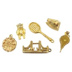 Six 9ct gold pendant/charms including Tower Bridge London, tennis racket, bear, Yorkshire rose and iron