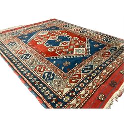 Turkish crimson ground rug, the hexagonal field with three overlapping lozenges with geometric stylised plant motifs, the multi-band border with repeating geometric designs and flower heads