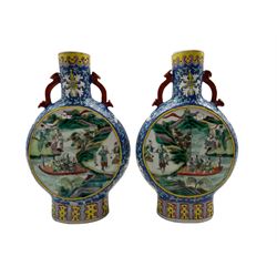 Pair of late 19th/ early 20th century Chinese Famille Verte pilgrim flasks/ vases, both having two panels depicting scenes of figures within landscape settings on blue ground decorated with scrolling foliage and Ruyi shaped handles, four character Kangxi mark beneath H24.5cm 
