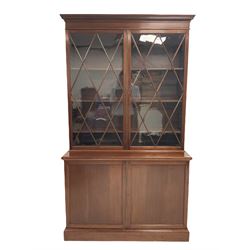 Georgian style mahogany display cabinet, the projecting dental cornice over two glazed doors of astragal design opening to reveal three adjustable shelves, over two cupboards with one shelf, raised on a plinth base 
