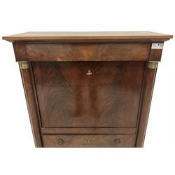 Early 19th century French Empire mahogany Secrétaire à Abattant, fitted with frieze drawer over a figured fall-front, enclosing central shelf with column supports over six assorted correspondence drawers, over three long drawers, flanked by recessed half-canted pilasters with embossed brass capitals, shaped skirted base o compressed bun feet