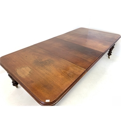 Large Victorian mahogany wind out extending dining table, the rectangular moulded top with rounded corners raised on turned carved supports terminating in brass cup and ceramic castors, 
