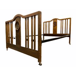 Early 20th century oak 4' 6'' double bedstead, the slatted head and footboard carved with acanthus leaf roundels, raised on later castors 