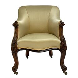 Victorian rosewood armchair, scroll carved arm terminals and floral carved uprights, upholstered in pale yellow fabric, on cabriole supports with brass castors, sprung seat