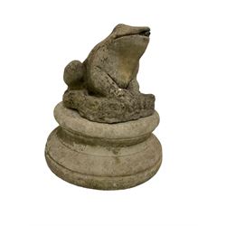 Composite stone garden ornament or water feature in the form of a crouching frog, water spout in the mouth, raised on a separate circular stepped plinth base