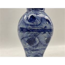 Chinese Kangxi blue and white vase of octagonal baluster form with flared rim, decorated throughout with bands of scrolling foliage, H30cm 