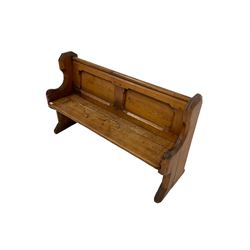 Late 19th century rustic pine church pew or bench, the shaped cresting rail over panelled back with swept end supports