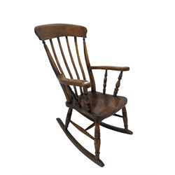 20th century rocking chair, the cresting rail over railed back leading into elm seat, raised on turned supports united by a stretcher 
