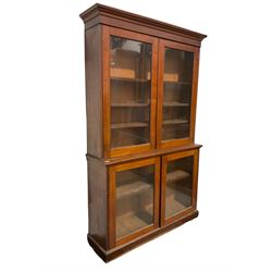 19th century mahogany display cabinet, the projecting cornice over two glazed doors opening to reveal three adjustable shelves over two glazed doors with two adjustable shelves, raised on a plinth base 