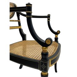 Regency design ebonised and parcel gilt finish elbow chair, the cane work back painted with bow and arrows with quiver and laurel leaf crown, swept arms with scrolled terminals flanking cane work seat, turned front supports with out-splayed feet
