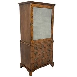 George II walnut cabinet on chest, top section with mirror panelled door and banded border concealing three adjustable shelves, the lower section fitted with four graduating drawers, each with bookmatched veneer fronts, raised on shaped bracket feet, stamped 'RE' to inside of drawers